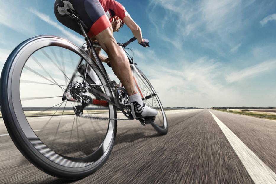 Ein Radfahrer fährt auf einer Landstraße entlang.