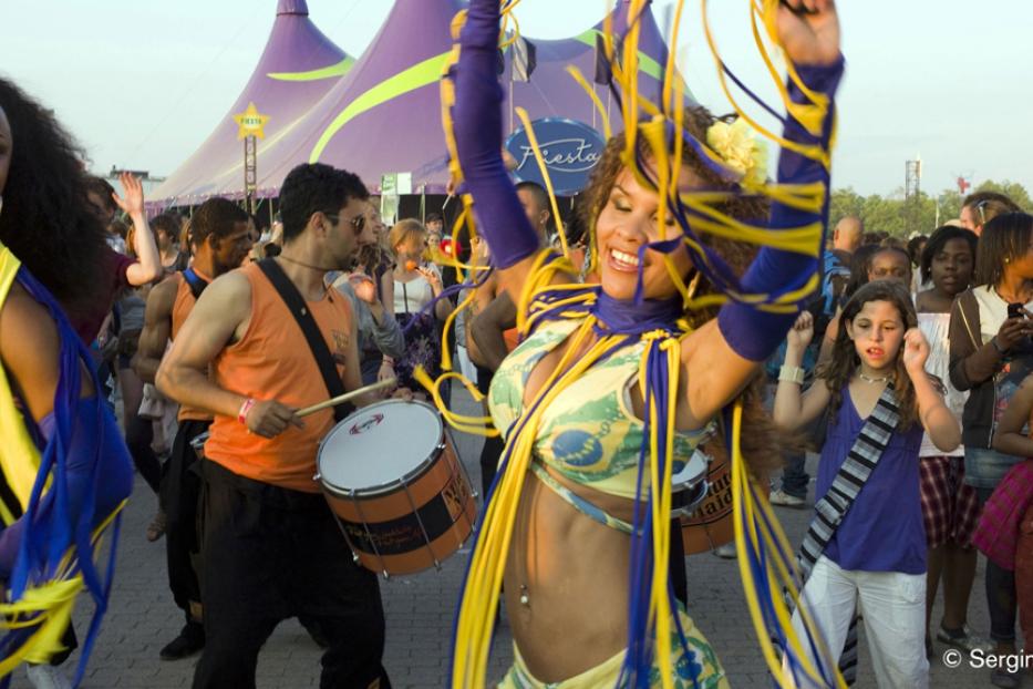 Eine Gruppe von Menschen feiert mit Musik und Tanz auf einem Festival.