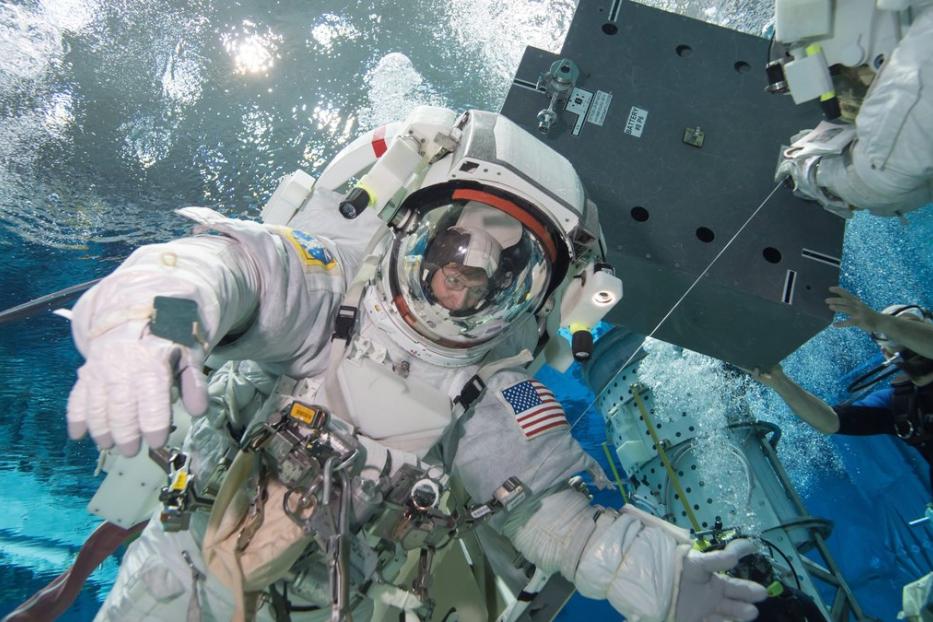 Ein Astronaut trainiert in einem Raumanzug unter Wasser.