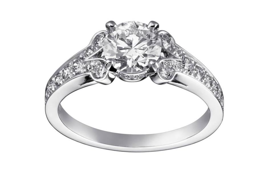 Ein silberner Ring mit einem großen Diamanten und kleineren Diamanten auf dem Ringband.