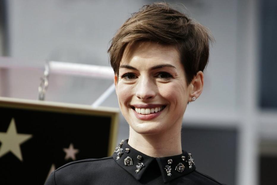 Anne Hathaway lächelt neben einem Stern auf dem Hollywood Walk of Fame.