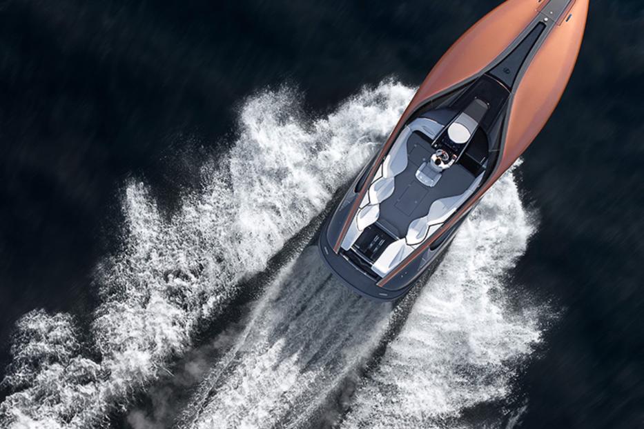 Ein bronzefarbenes Motorboot fährt schnell auf dunklem Wasser.