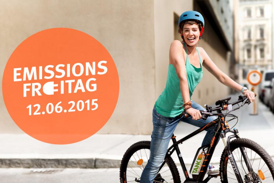 Eine junge Frau mit Helm fährt lachend auf einem E-Bike durch die Stadt.