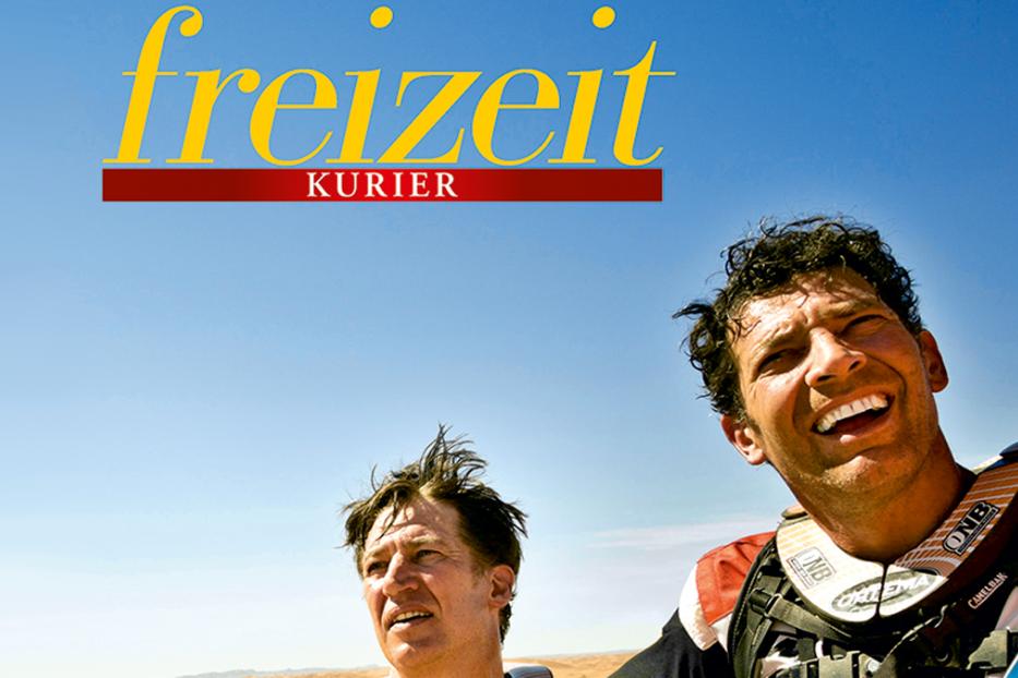 Zwei Männer stehen in der Wüste unter dem Schriftzug „Freizeit Kurier“.