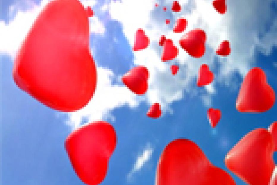 Viele rote Herzballons steigen vor einem blauem Himmel auf.