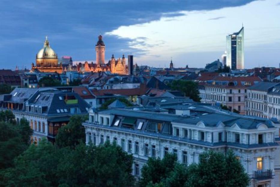 Blick auf die Skyline von Leipzig mit dem Neuen Rathaus und dem City-Hochhaus im Abendlicht.