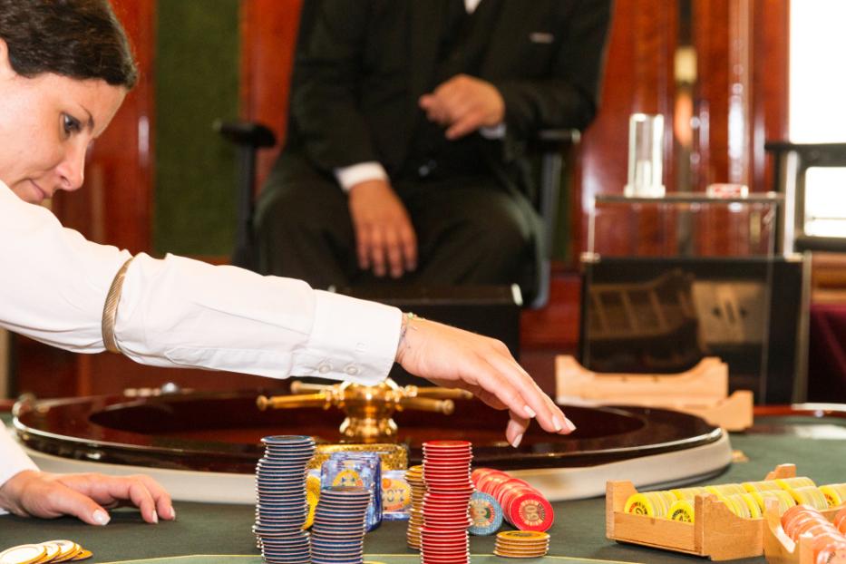 Eine Croupier dreht das Rouletterad in einem Casino.