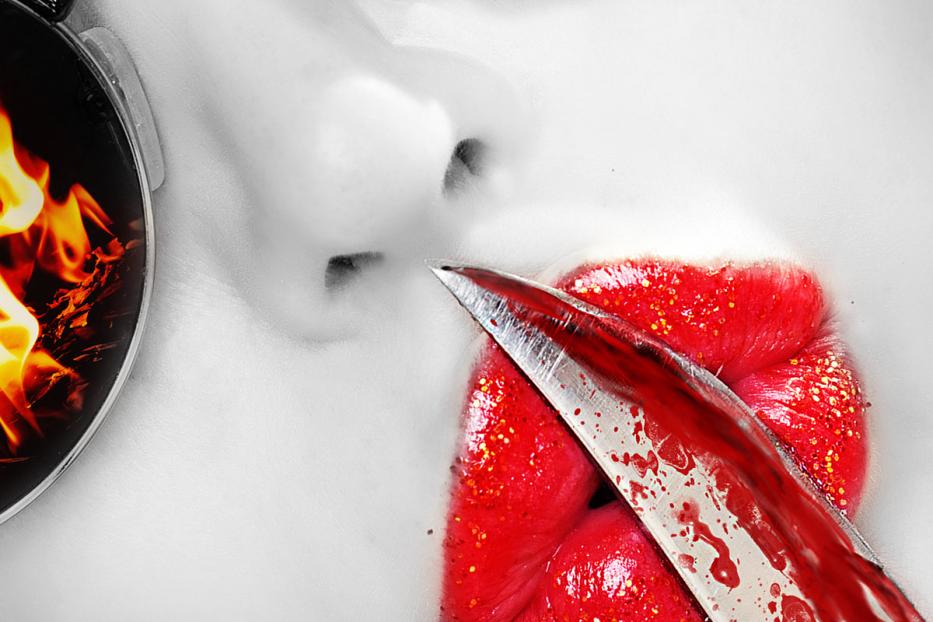 Das Gesicht einer Person mit einer Messerklinge vor den roten Lippen und einer Sonnenbrille, die Flammen reflektiert.