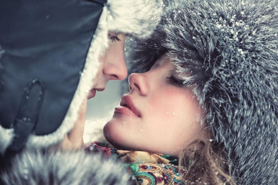 Ein Paar mit Wintermützen, deren Gesichter sich fast berühren.