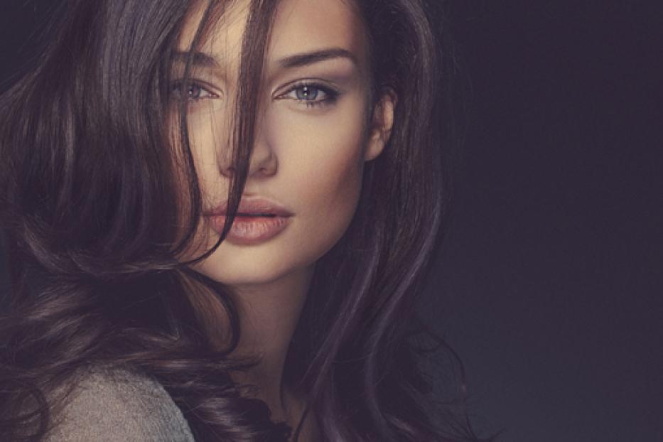 Porträt einer Frau mit langen, gewellten, dunklen Haaren.