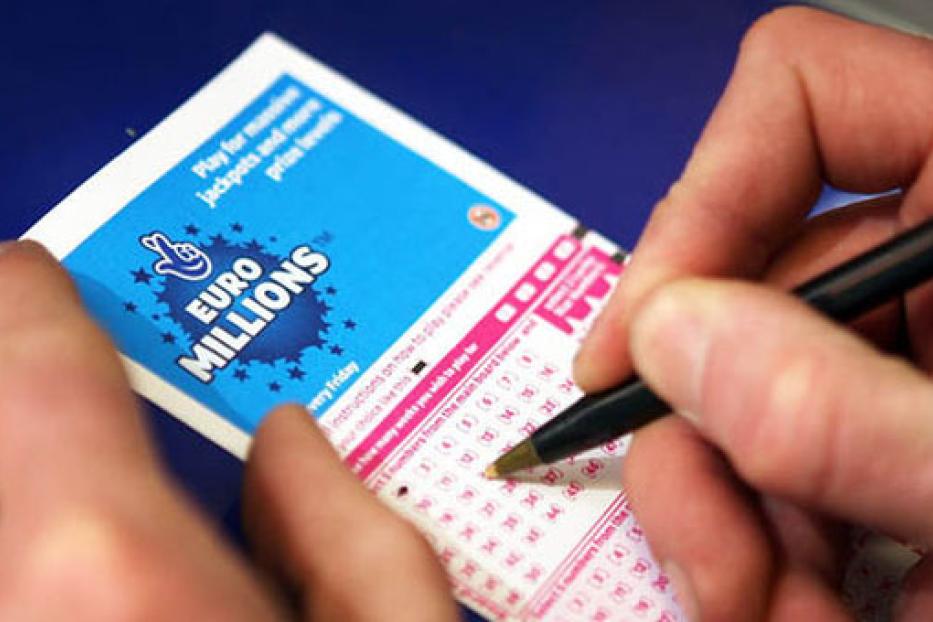 Eine Person füllt einen EuroMillions-Lottoschein aus.