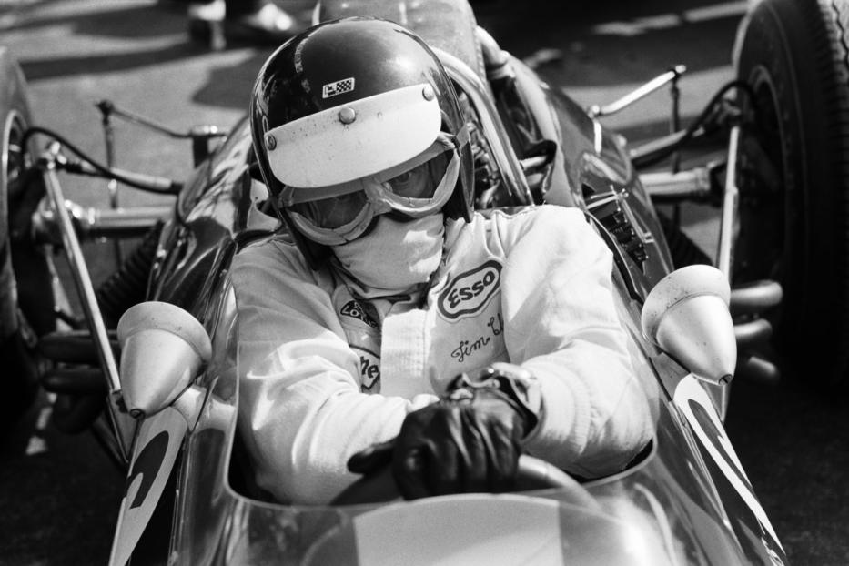 Ein Rennfahrer mit Helm und Schutzbrille sitzt in seinem Rennwagen.