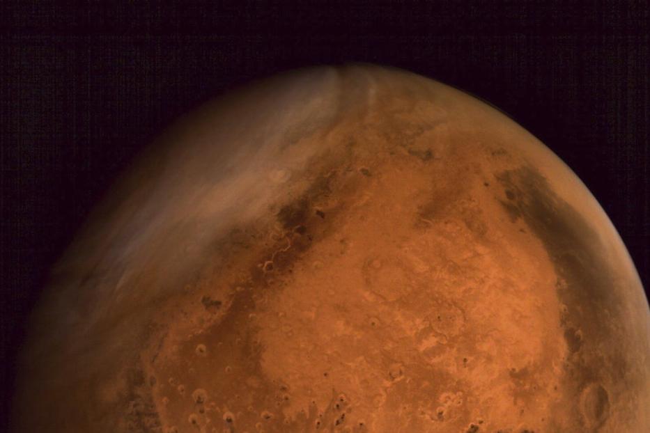 Eine Nahaufnahme des Planeten Mars vor einem dunklen Hintergrund.