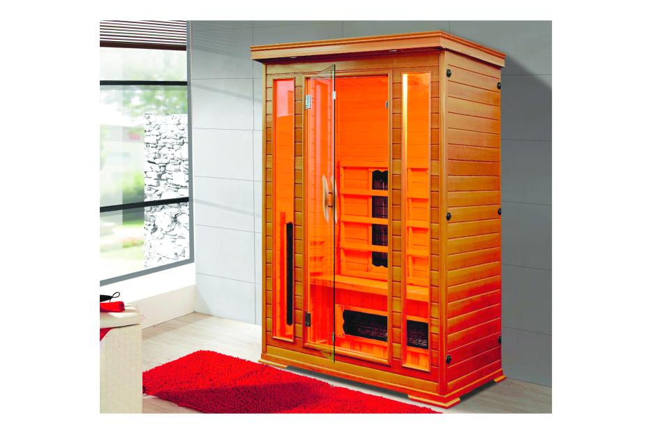 Eine hölzerne Infrarotsauna mit Glastür steht in einem Badezimmer.
