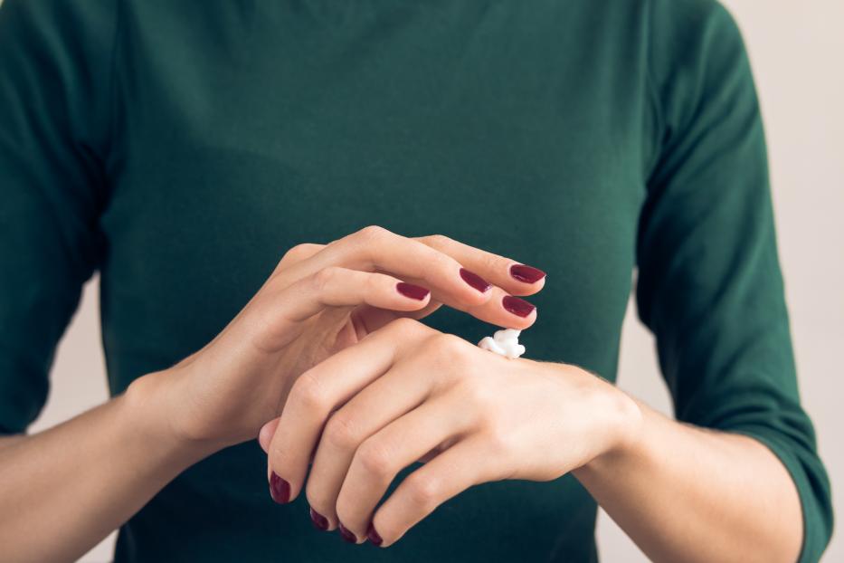 Woman in a green T-shirt and a maroon manicure