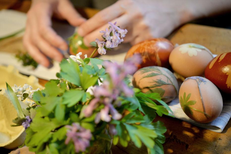 Bunte Ostereier mit Pflanzenmotiven werden verziert.