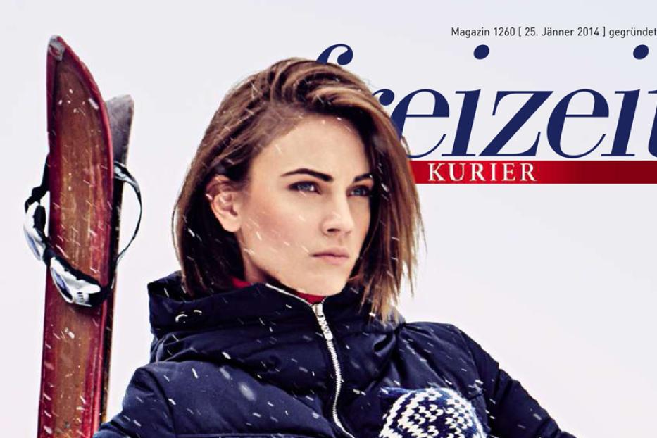 Eine Frau mit Skiern vor dem Hintergrund des „Freizeit Kurier“-Magazins.
