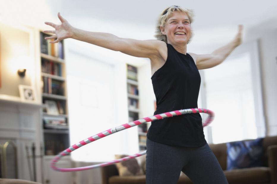 Frau hat Spaß an Bewegung mit Hula Hoop-Reifen