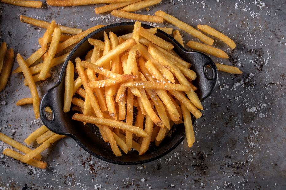 Eine Schale voller goldgelber, gesalzener Pommes Frites.