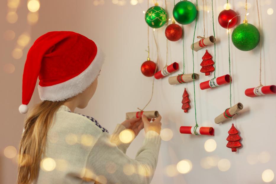 Ein Mädchen öffnet ein Kästchen bei einem Adventkalender.