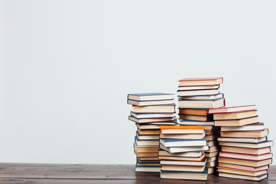 many stacks of educational books at home preparing for exams on a white background