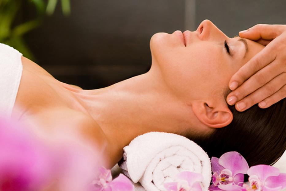 Eine Frau entspannt sich bei einer Kopfmassage in einem Spa.