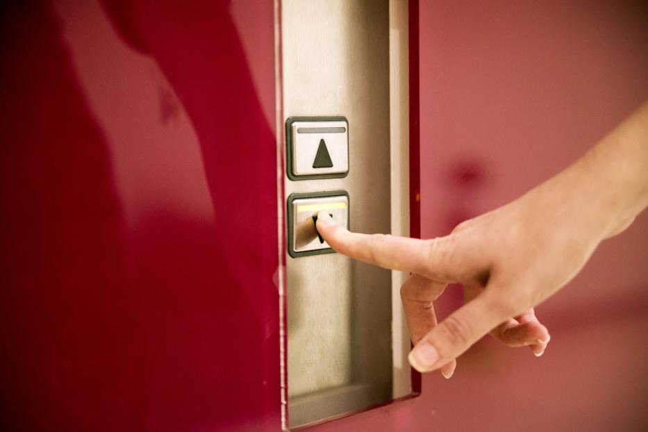 Woman pressing elevator button to go down