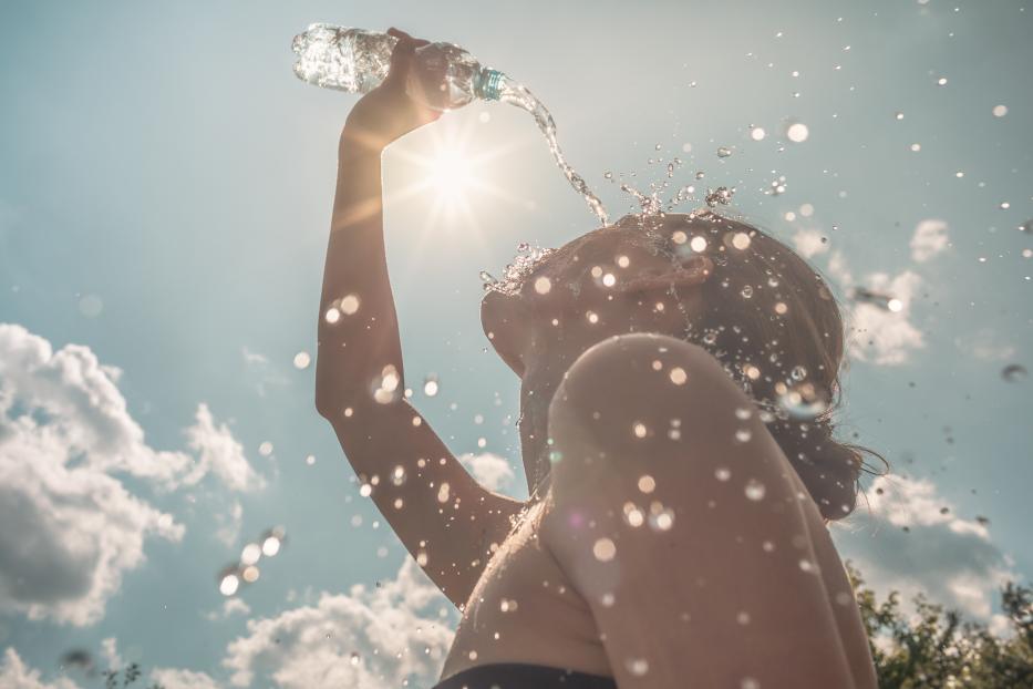 Woman cooling herself with water on a hot summer day