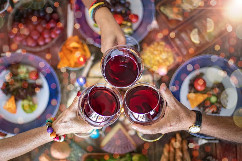 Family dinner for a celebration with red wine and cheers.