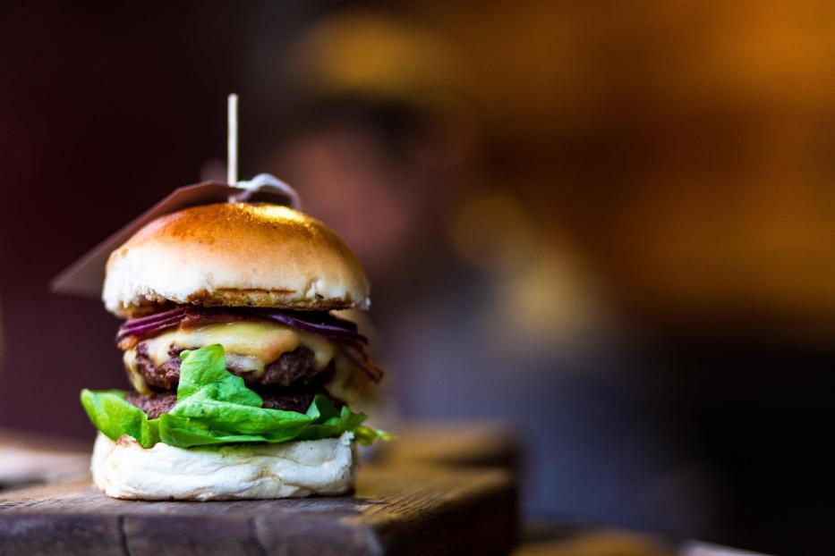 Fresh flame grilled burger with chef defocused in background