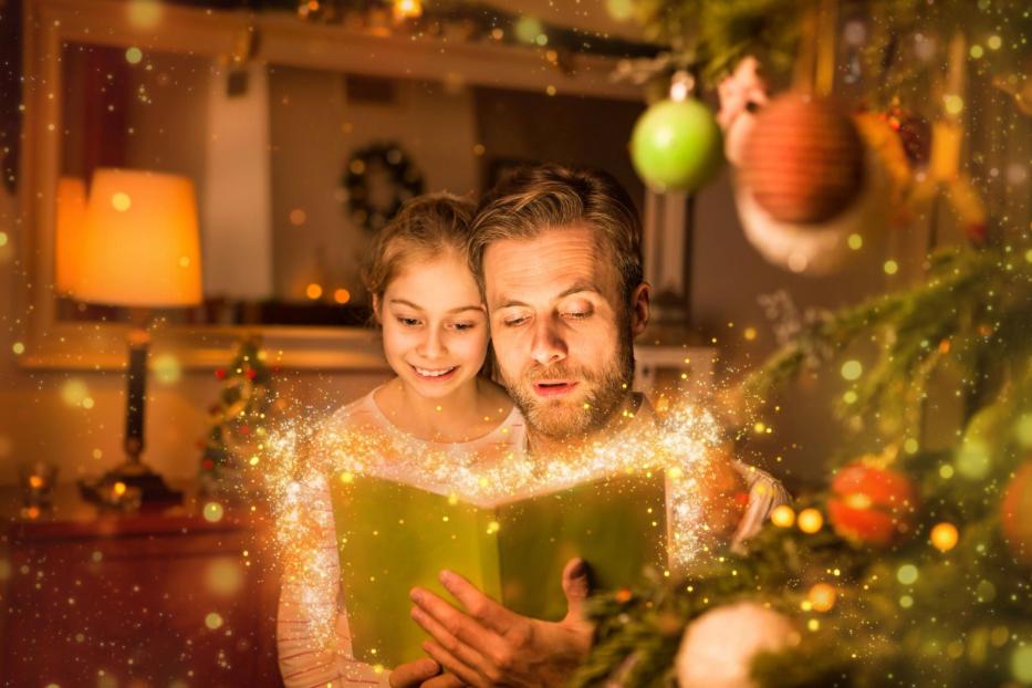 Christmas - father and daughter reading book at home