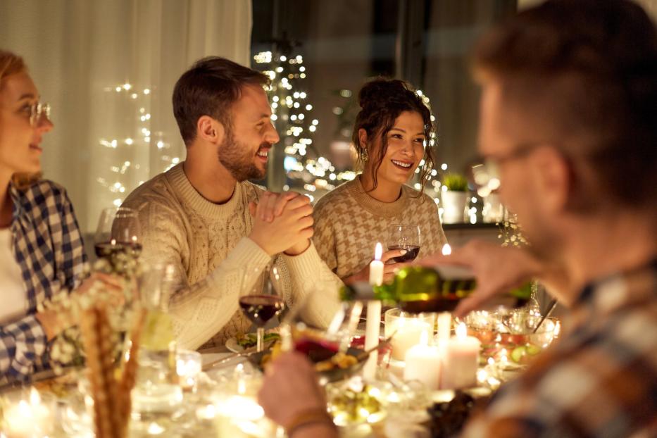 veganes Weihnachtsessen, Kerzenschein, Familie am Esstisch, Rotwein, Tischdeko