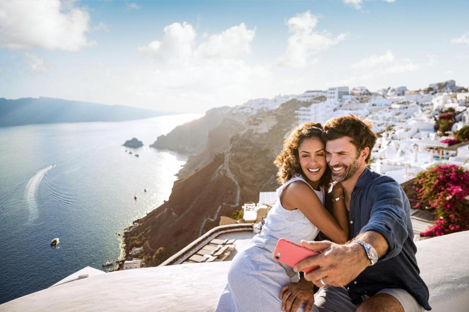 Paar macht Selfie mit dem Panorama von Santorin