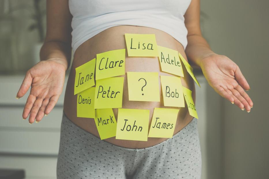 Toned Schuss von schwangeren Frau mit Kindernamen auf Bauch - Stock-Fotografie