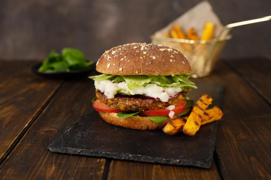 Köstliche frische hausgemachte vegane Linsen Burger auf einem rustikalen dunklen Hintergrund - Stock-Fotografie