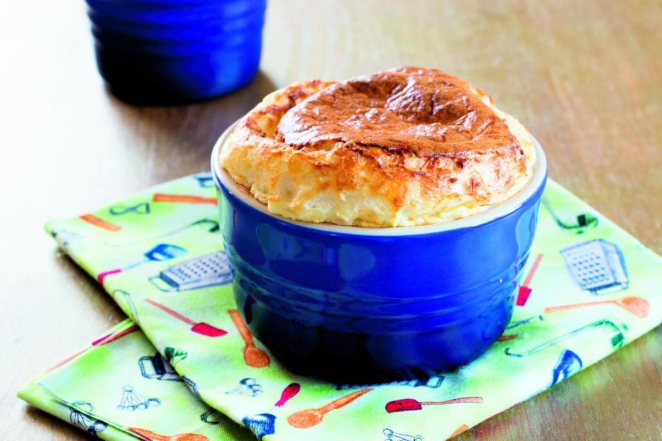 Zwei Soufflés in blauen Förmchen auf einem Küchentuch.