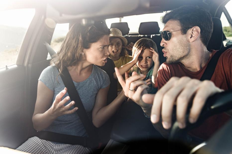 Eltern streiten im Auto, Kinder sitzen auf der Rückbank und halten sich die Ohren zu, Krise im Urlaub