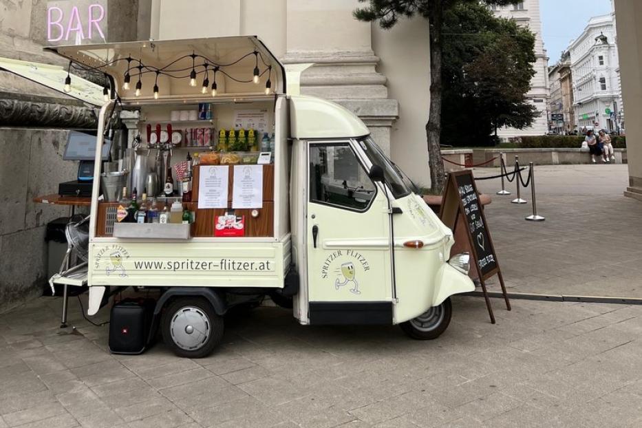 Der Spritzer-Flitzer ist vor der Karlskirche geparkt und schenkt Weißen Spritzer aus