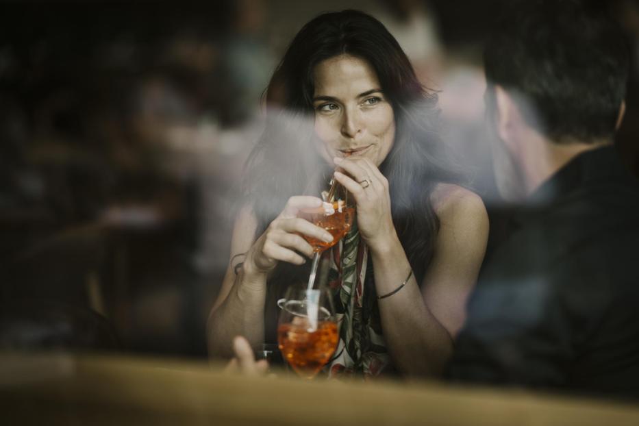 Woman enjoying drink with boyfriend in restaurant - Stock-Fotografie