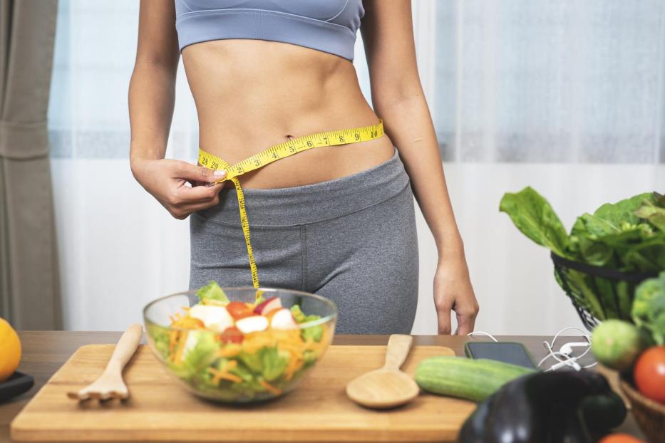 Woman measuring her waist - Stock-Fotografie