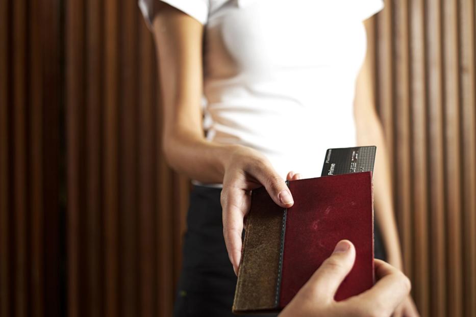 Waitress returning credit card to diner, mid section - Stock-Fotografie