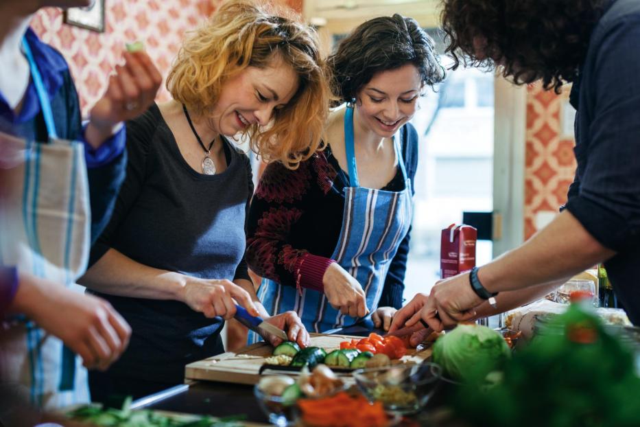 Cooking class participants enjoy cutting vegetable - Stock-Fotografie