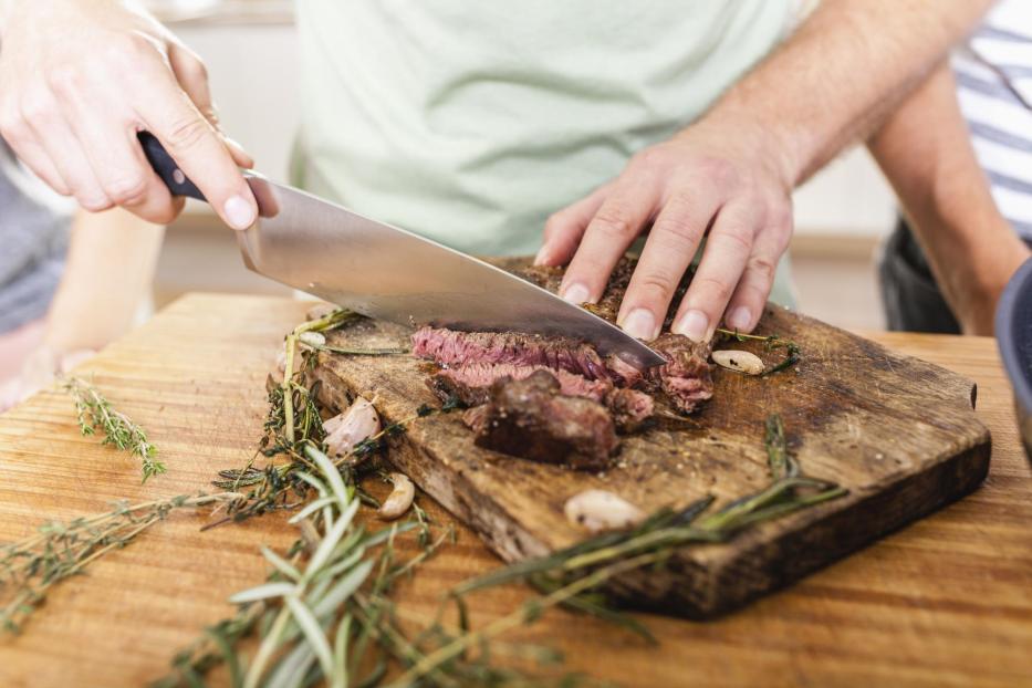 Cutting steak on chopping board - Stock-Fotografie