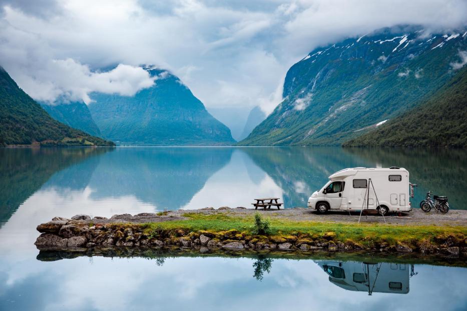 Wohnmobil vor Panorama mit einem See und Bergen