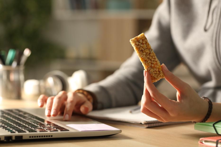 Eine Frau snackt beim Arbeiten