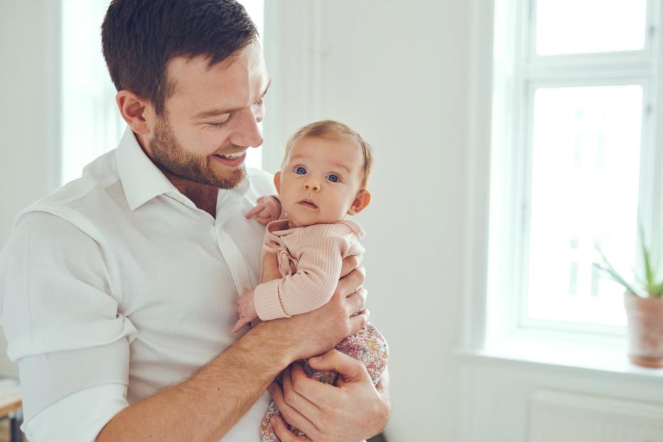 Vater posiert stolz mit Baby