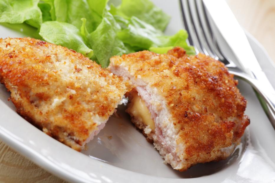 Cordon bleu mit schmelzendem Käse und Schinken auf einem Teller mit Salat