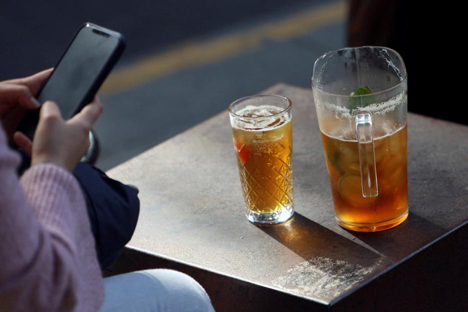 Eine Person sitzt im Wetherspoon und tippt ins Handy, vor ihr zwei Bier.