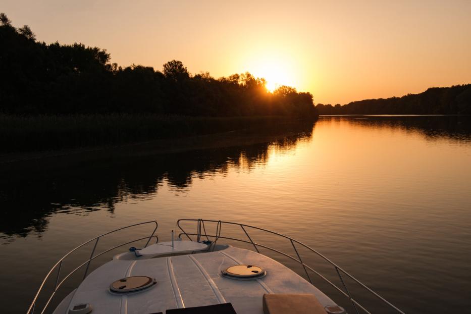 Hausboot auf der Theiß in Ungarn bei Sonnenuntergang, Blick aufs Wasser