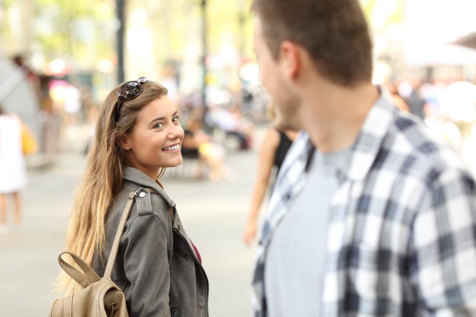 Junge Frau flirtet mit einem fremden Mann.